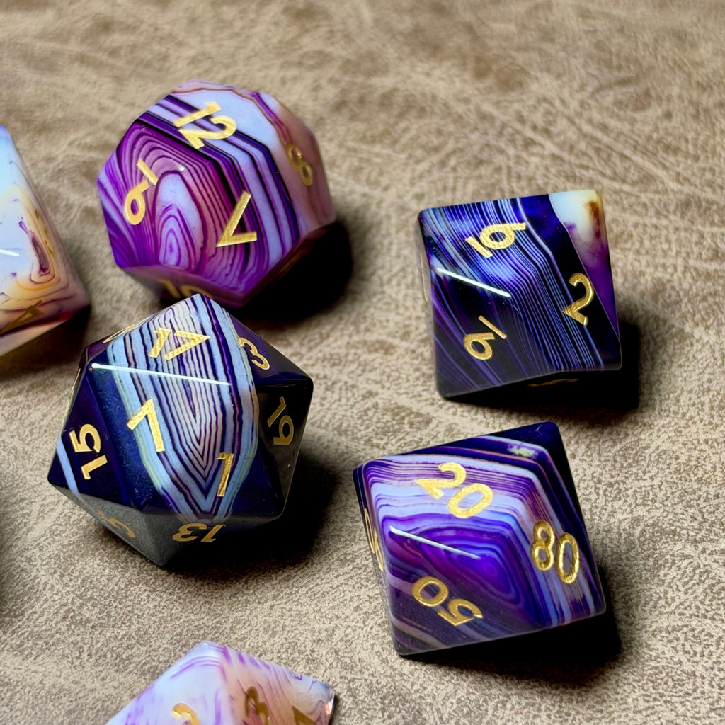 Violet Strata polished natural stone dice showing layered purple banding